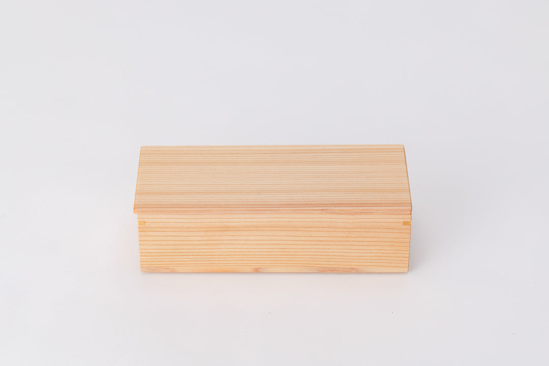 A rectangular box made of light-colored cedar sits on a white background with its lid closed. The long edge of the box faces the viewer.