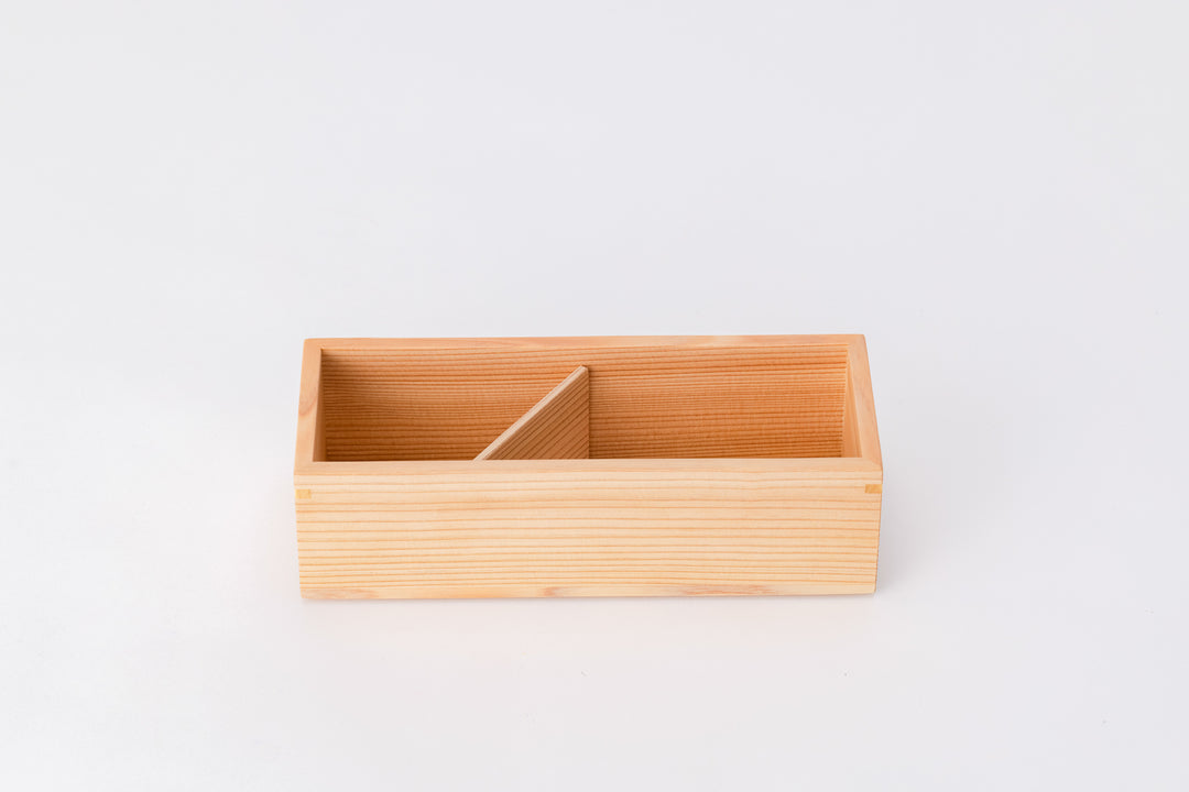 A rectangular box made of light-colored cedar sits on a white background with no lid on it. Inside the box is a wooden divider that separates the box into two sections.